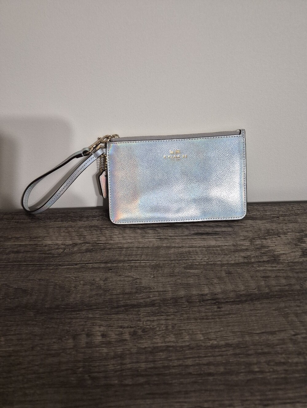 Coach F65517 Corner Zip Wristlet in Silver Hologram with an iridescent oil-slick
